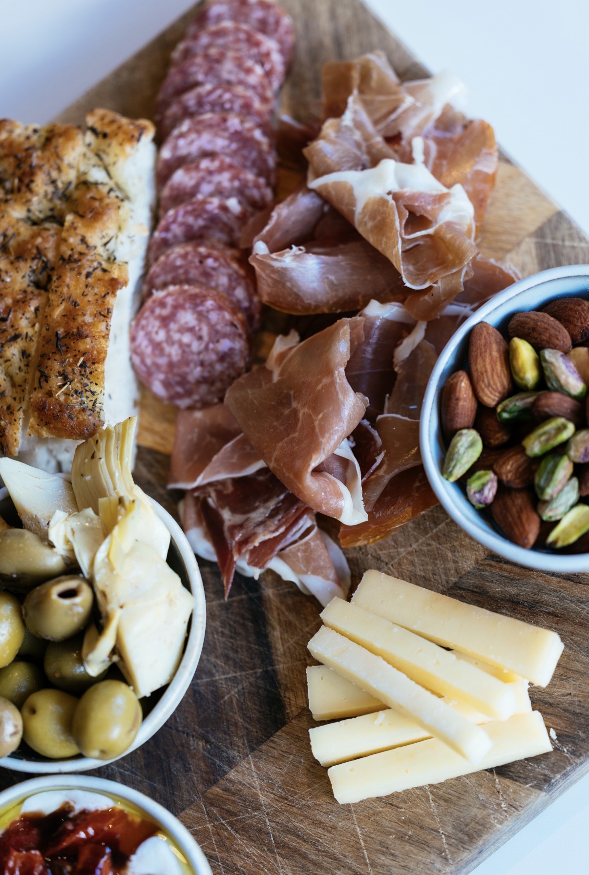 Nærbillede af charcuteri-tallerken med prosciutto, salami og snacks hos Ro På